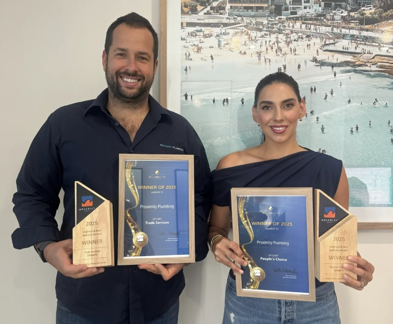 Award plaques from local business awards, held by the family owners