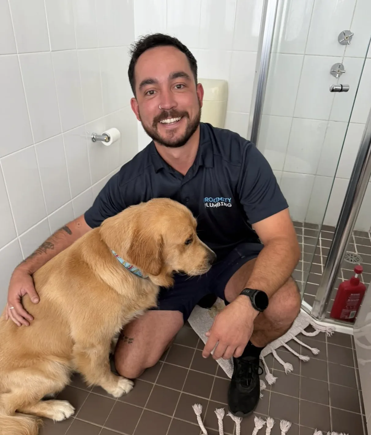 Plumber on a bathroom drain call-out, with the family dog supervising